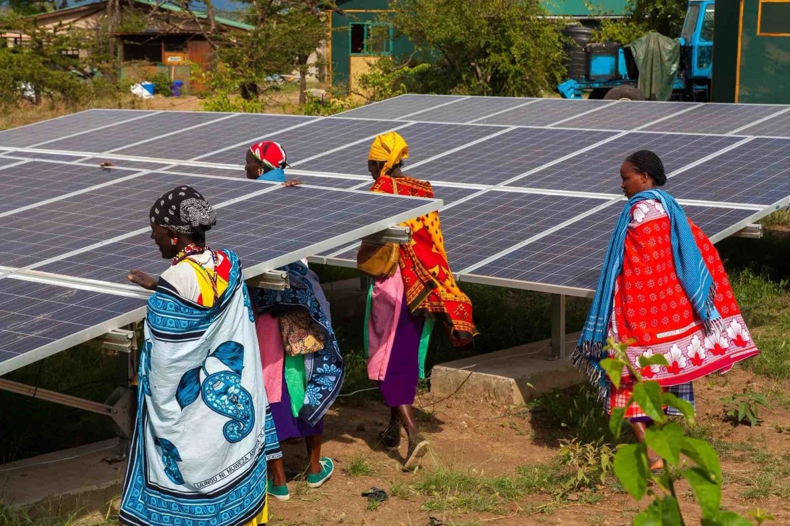 Community women walking beside solar panels